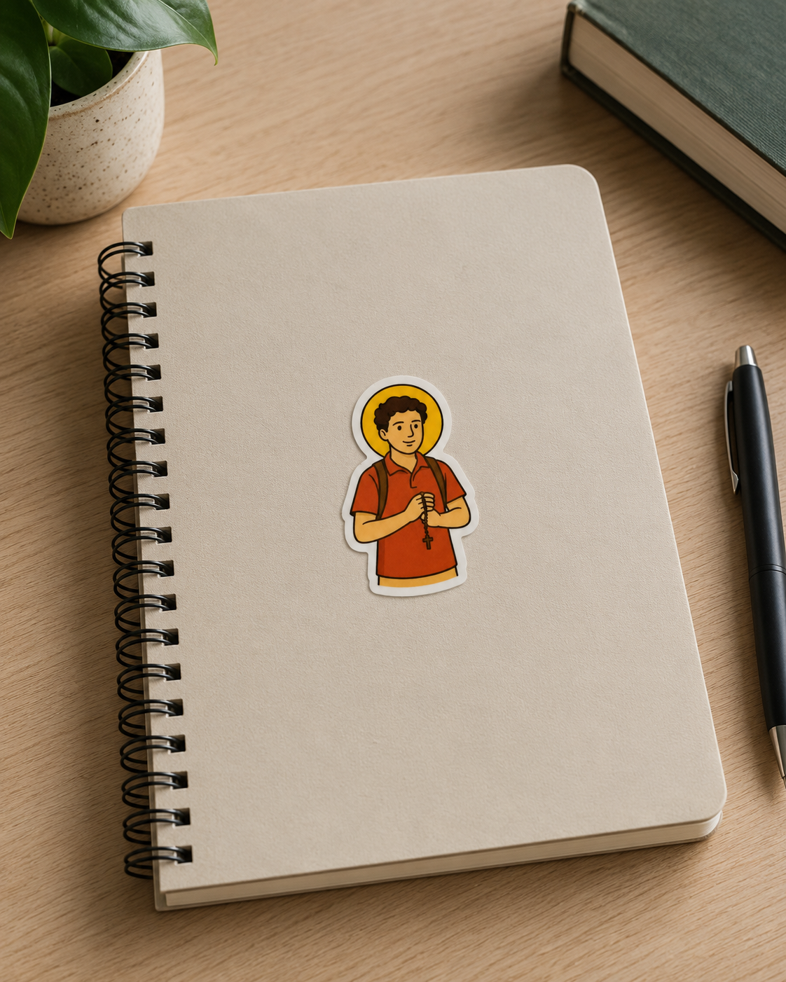 St. Carlo Acutis vinyl sticker on a notebook