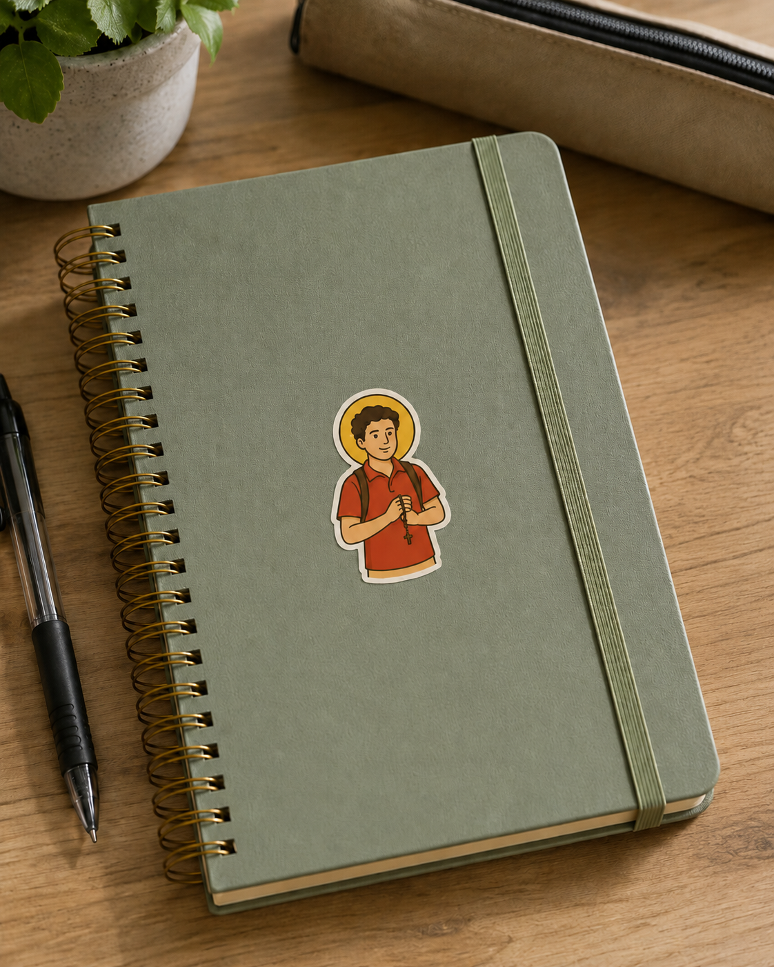 St. Carlo Acutis vinyl sticker on a notebook